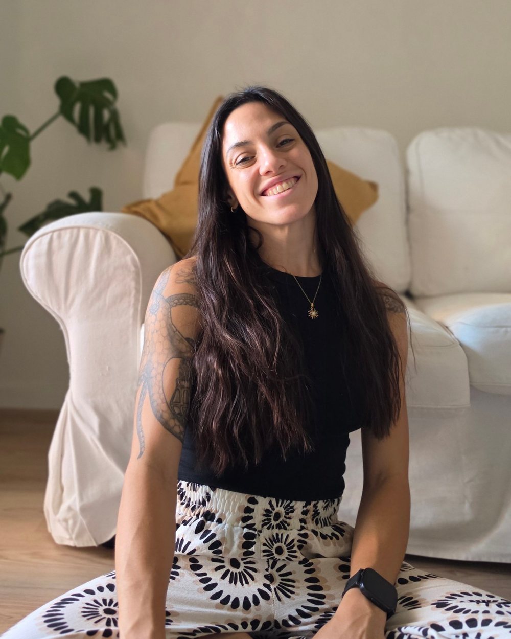 Ana sonriendo, sentada en el piso del living